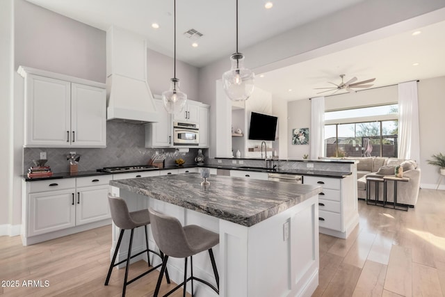 kitchen with white cabinetry, ceiling fan, tasteful backsplash, and hanging light fixtures