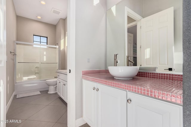 full bathroom with shower / bath combination with glass door, toilet, tile patterned floors, and vanity