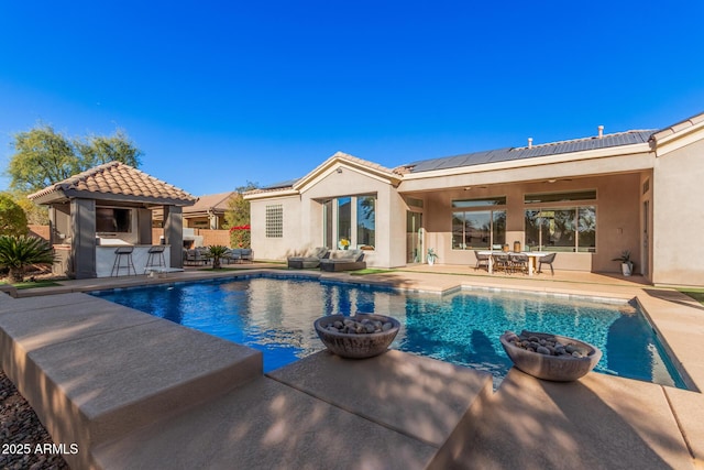 view of pool with an outdoor bar and a patio area