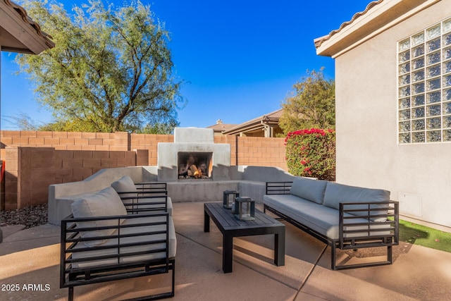 view of patio with an outdoor living space with a fireplace