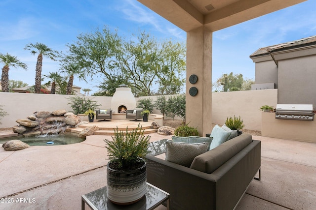 view of patio with area for grilling, grilling area, and an outdoor living space with a fireplace