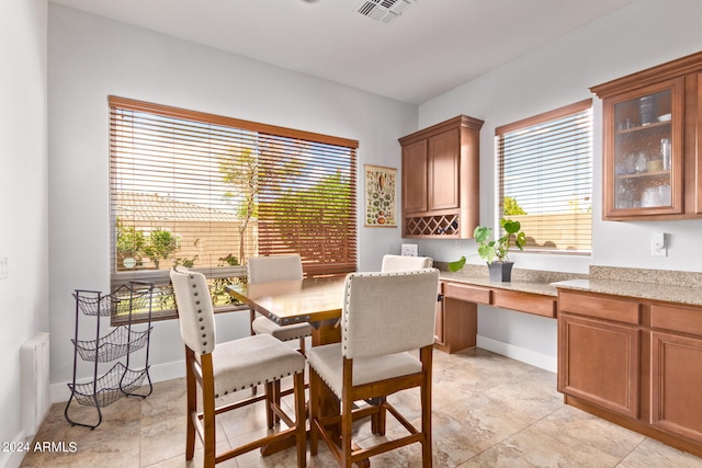 tiled dining room with a wealth of natural light, radiator heating unit, and built in desk