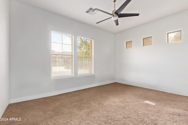 unfurnished room with ceiling fan and carpet