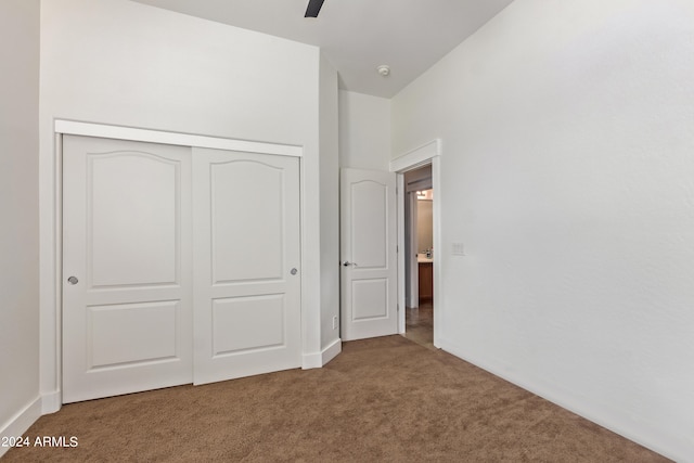 unfurnished bedroom with a closet, ceiling fan, and carpet floors