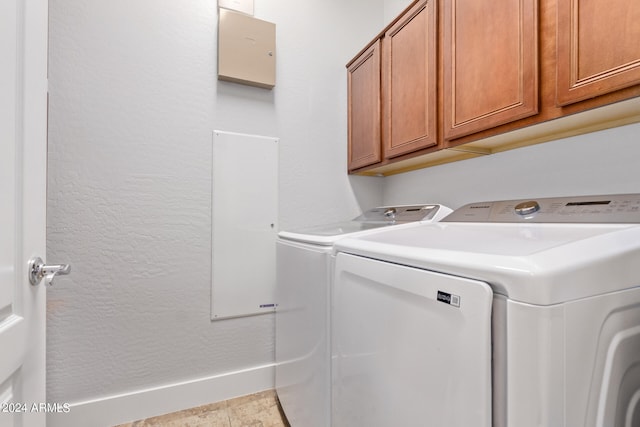 laundry room with washer and clothes dryer, cabinets, and light tile patterned floors