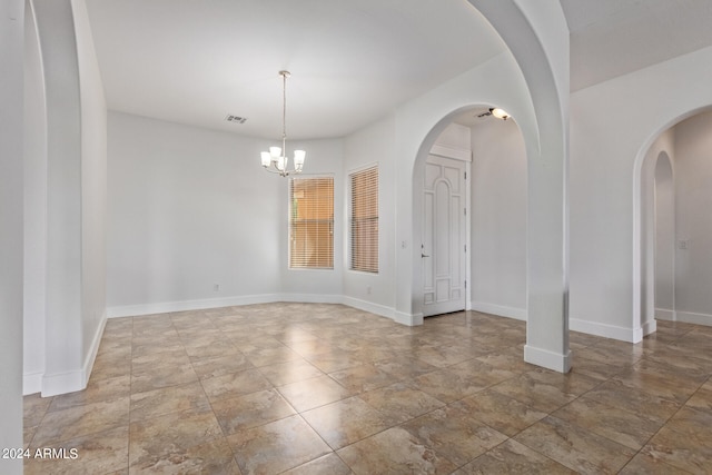 tiled empty room with a chandelier