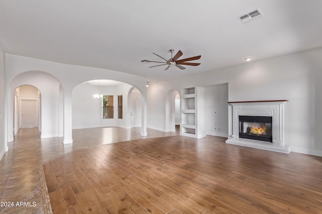 unfurnished living room with ceiling fan, light hardwood / wood-style floors, and built in features