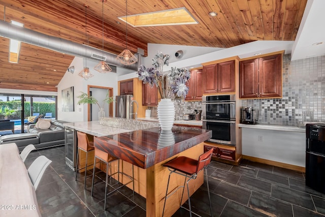 kitchen with wooden ceiling, stainless steel appliances, a breakfast bar, tasteful backsplash, and decorative light fixtures