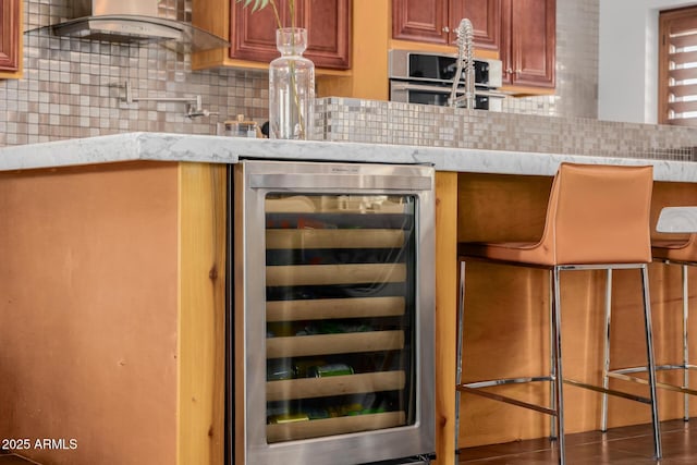 bar with beverage cooler, stainless steel oven, and decorative backsplash