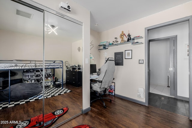 bedroom featuring baseboards, visible vents, and wood finished floors