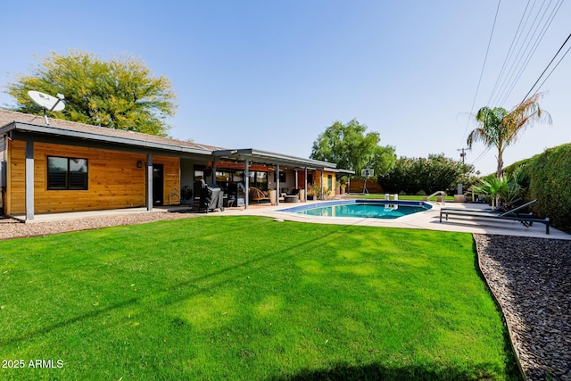 exterior space featuring a patio, a yard, and an outdoor pool