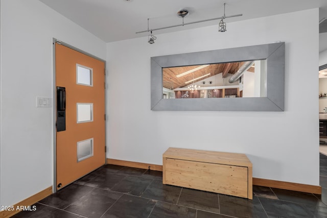 entryway with track lighting, wooden ceiling, and baseboards