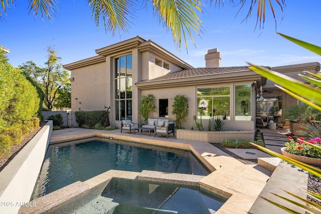 back of house featuring a patio, fence, an in ground hot tub, stucco siding, and a chimney