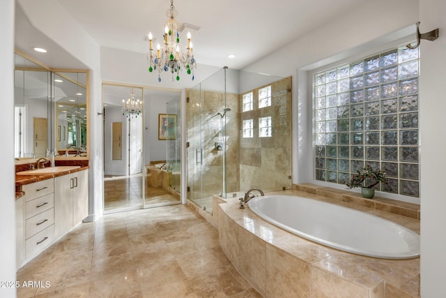 bathroom featuring recessed lighting, a stall shower, a bath, a notable chandelier, and vanity