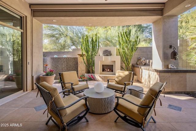 view of patio with an outdoor living space with a fireplace and a fenced backyard