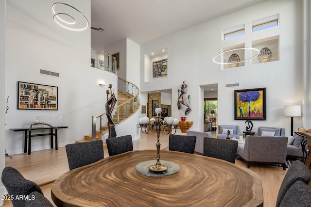 dining space with stairway, wood finished floors, and visible vents