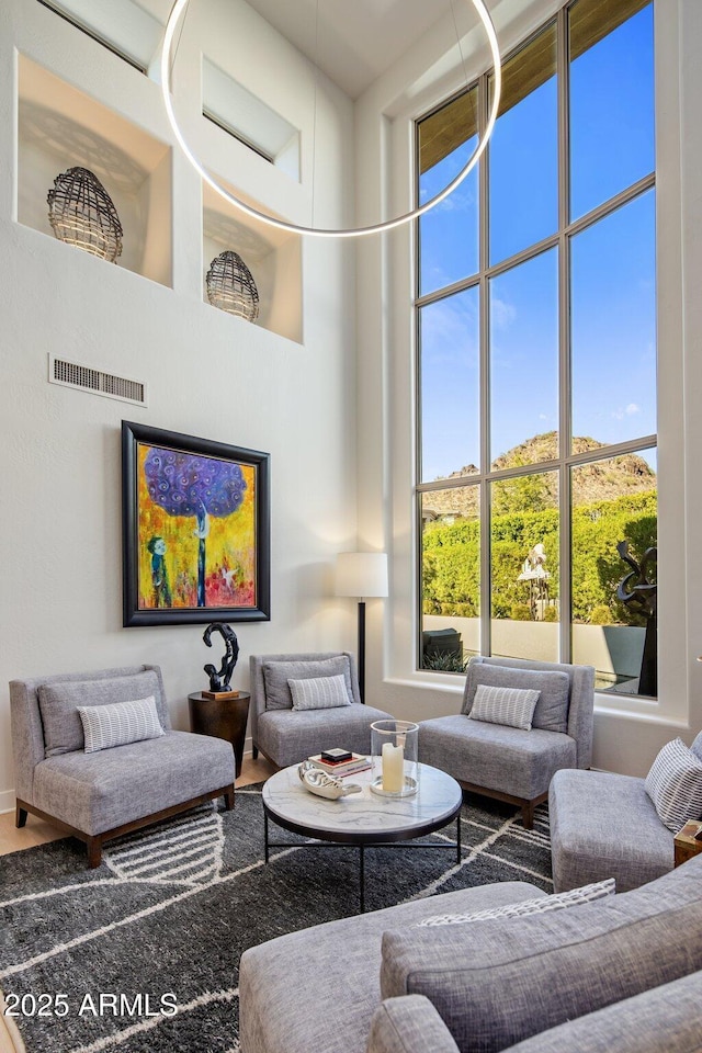 living area featuring visible vents and a high ceiling