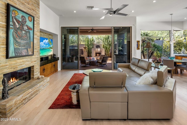 living area featuring visible vents, a ceiling fan, wood finished floors, recessed lighting, and a fireplace