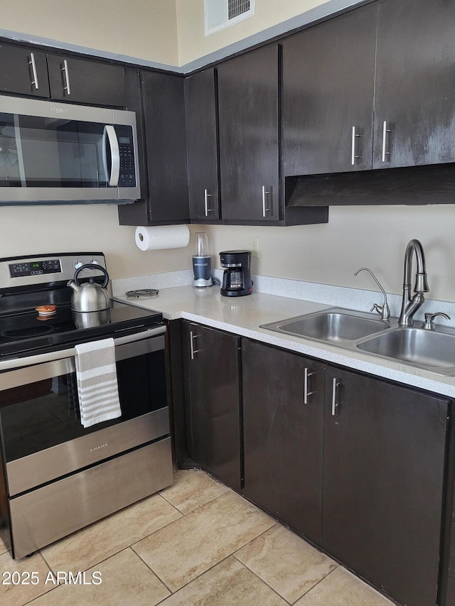 8221 E Garfield St Unit L109, Scottsdale, AZ 85257 - kitchen with stainless steel appliances, light countertops, and light tile patterned floors