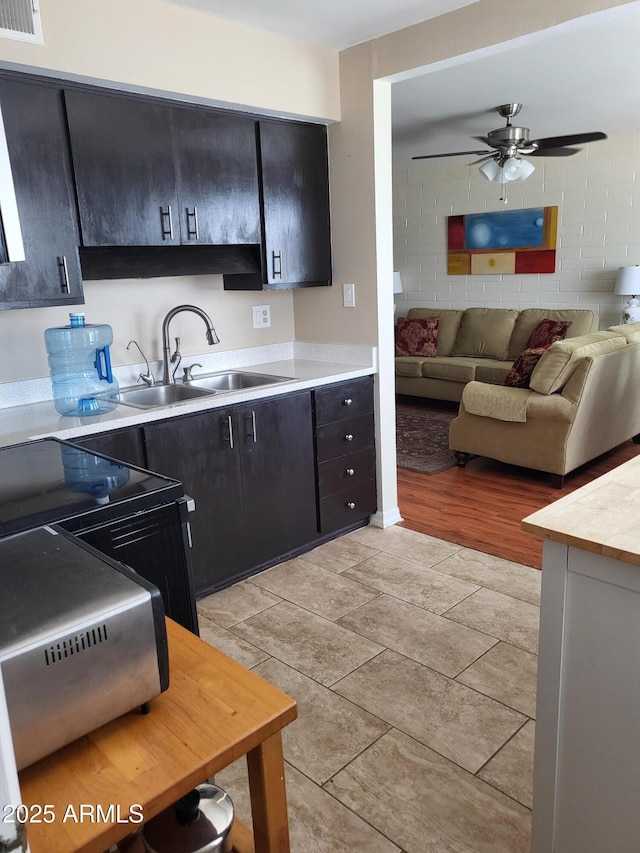 8221 E Garfield St Unit L109, Scottsdale, AZ 85257 - kitchen featuring light countertops, a ceiling fan, dark cabinetry, and open floor plan