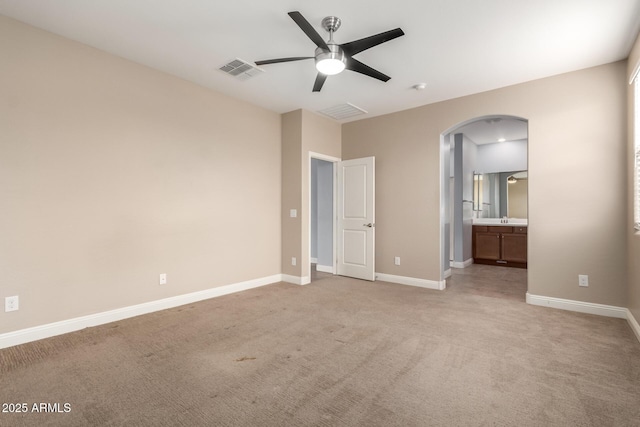 unfurnished bedroom with ceiling fan, light colored carpet, and connected bathroom