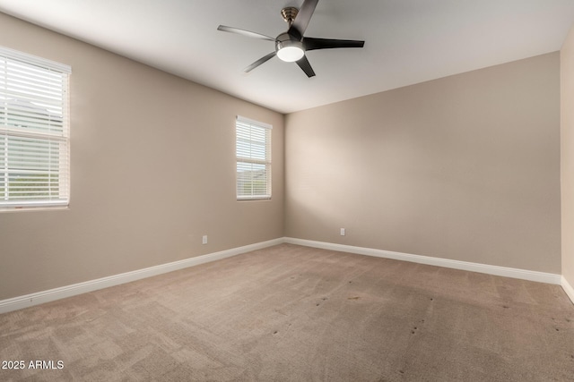 carpeted empty room featuring ceiling fan and plenty of natural light