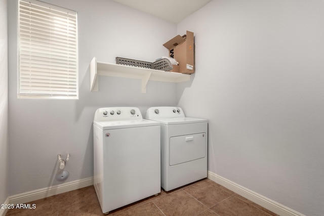 clothes washing area with light tile patterned floors and washer and clothes dryer