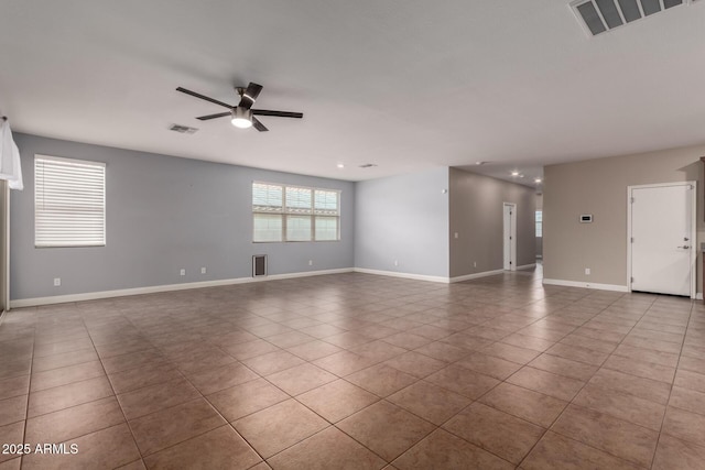 empty room with ceiling fan and light tile patterned floors