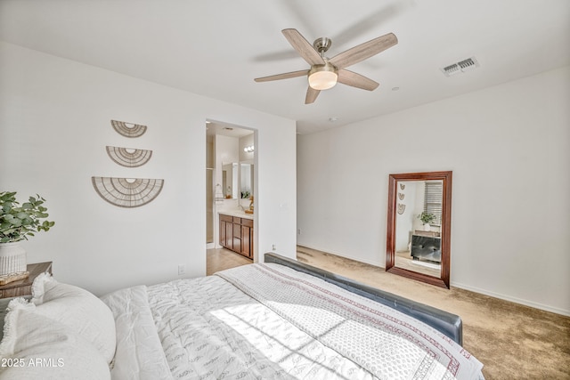 carpeted bedroom featuring ensuite bath and ceiling fan