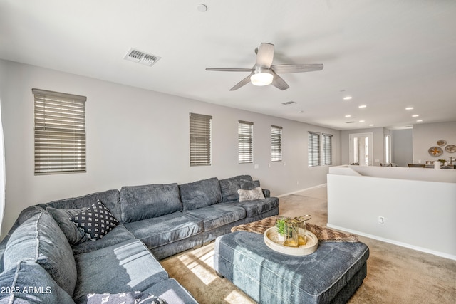 carpeted living room with ceiling fan