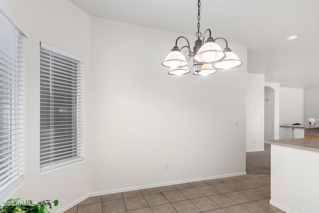 12355 W Hadley St, Avondale, AZ 85323 - unfurnished dining area featuring light tile patterned floors, a chandelier, arched walkways, and baseboards