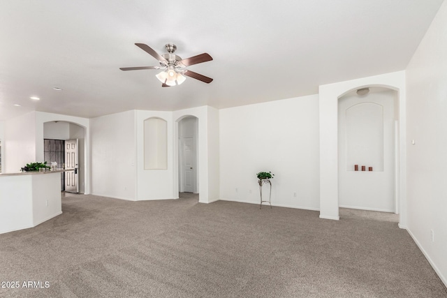 12355 W Hadley St, Avondale, AZ 85323 - unfurnished living room with arched walkways, a ceiling fan, carpet, baseboards, and recessed lighting