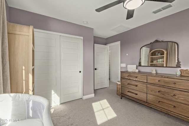 bedroom with a closet, ceiling fan, and light colored carpet