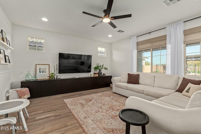 living room featuring light hardwood / wood-style flooring and ceiling fan