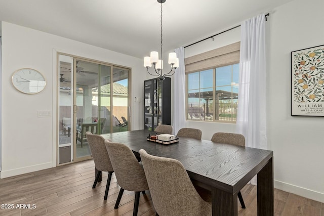 dining space featuring wood-type flooring, a wealth of natural light, and a notable chandelier