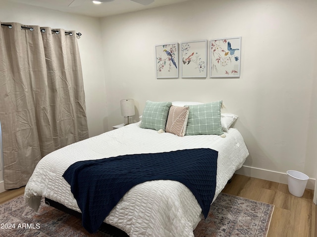 bedroom featuring wood finished floors and baseboards