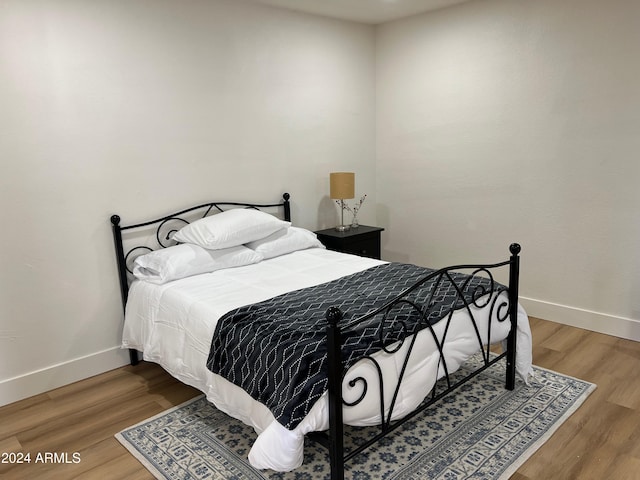 bedroom featuring baseboards and wood finished floors