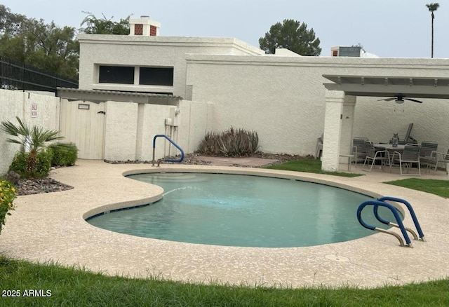 outdoor pool featuring a patio, ceiling fan, and fence