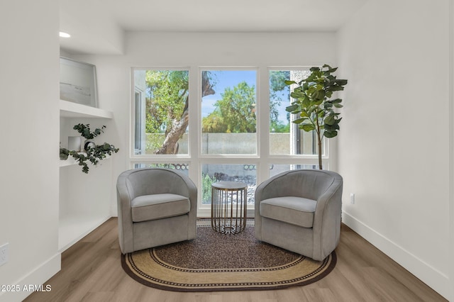 living area with wood finished floors and baseboards
