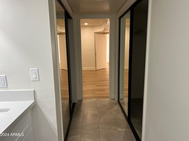 hallway with tile patterned flooring and baseboards