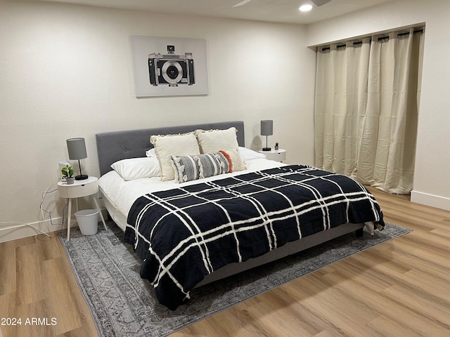 bedroom with wood finished floors, baseboards, and recessed lighting