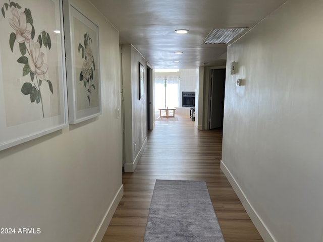 hall with baseboards and wood finished floors