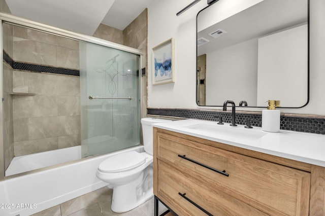 full bathroom with tile patterned floors, toilet, vanity, and enclosed tub / shower combo
