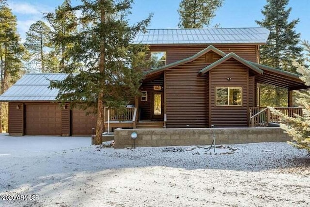 log cabin featuring a porch and a garage