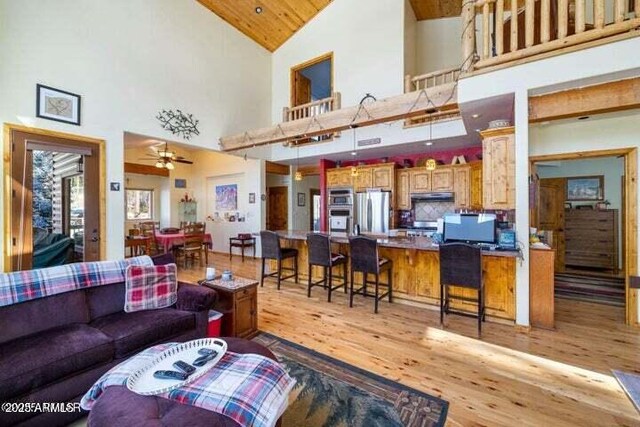 living room featuring high vaulted ceiling, wooden ceiling, ceiling fan, and light hardwood / wood-style flooring