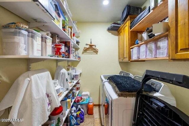 laundry room featuring washing machine and dryer and cabinets