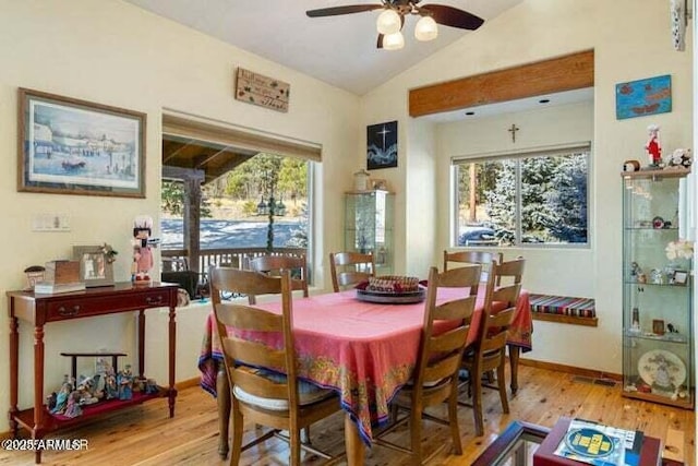 dining area with ceiling fan, light hardwood / wood-style floors, and vaulted ceiling