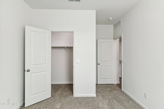 unfurnished bedroom featuring carpet, a closet, visible vents, and baseboards