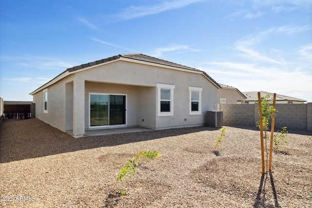 rear view of property featuring a patio area, central air condition unit, a fenced backyard, and stucco siding