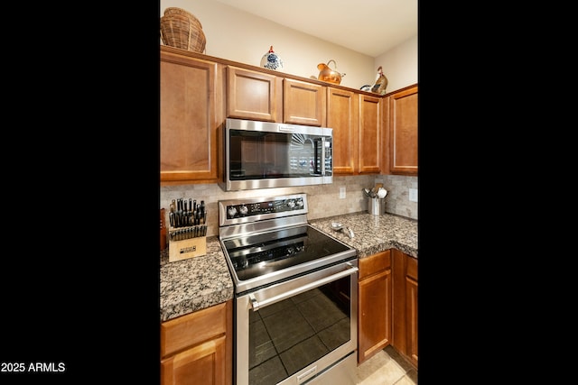 4245 E Ficus Way, Gilbert, AZ 85298 - kitchen with stainless steel appliances, tasteful backsplash, light tile patterned floors, brown cabinets, and light countertops